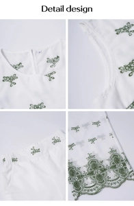 Detail view of green floral embroidery and scalloped lace hem on white two-piece set