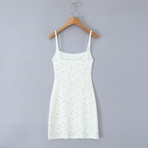 Détail de la mini-robe en maille côtelée blanche fleurie avec bordure en dentelle fine