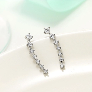 Macro shot of curved silver stud earrings with sparkling white cubic zirconia rows