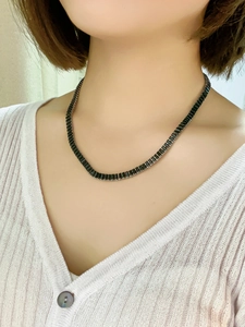 Elegantly styled emerald green rectangular zircon necklace on a model's neck