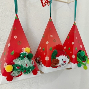 Trois chaussettes de Noël en polaire corail dans des boîtes cadeaux pyramides au mur