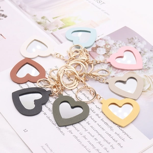 Flat lay of colorful heart-shaped PU leather mirror keychains in various soft pastel tones