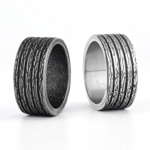 Macro shot of Viking style wide rings with vintage bark texture in black and silver finishes