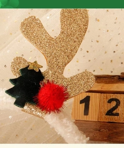Close-up of Christmas antler headband with gold glitter, green tree and red pompom