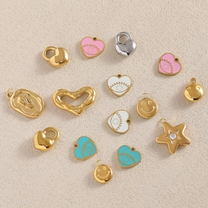 Flat lay of 18K gold-plated enamel charms including hearts, stars and smiley faces