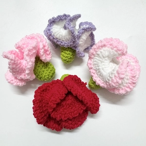 Close-up of handmade crochet flowers in red, pink, and purple yarn with detailed textures