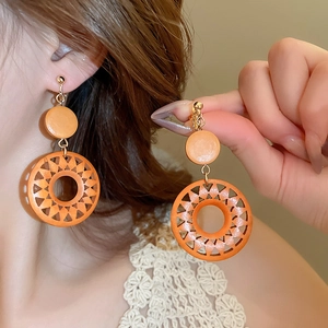 Retro hollow wooden round sun drop earrings in orange color with geometric clip-on design
