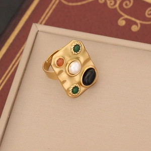Macro shot of gold hammer-textured ring with pearl and colorful gemstone details