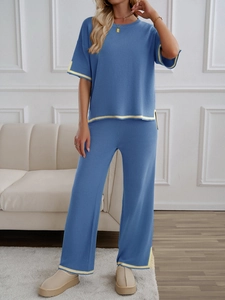 Detail view of blue knitted set with yellow contrast trim on sleeves and pant cuffs