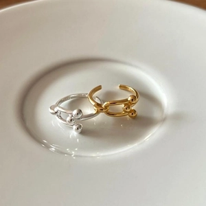 Detail of gold and silver S925 sterling silver ball rings on a white ceramic plate