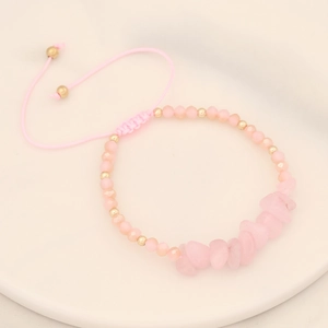 Detailed macro shot of handmade braided pink crystal bracelet with natural raw stones