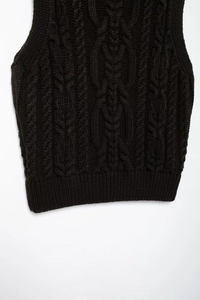 Close-up of black cable knit sweater vest showing detailed texture and ribbed collar