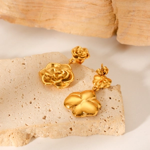 Elegant 18K gold-plated stainless steel rose flower drop earrings on a natural stone base