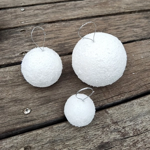 Detailed view of white glitter foam snowballs in three sizes with silver hanging strings