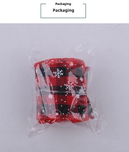 Roll of red and black buffalo plaid Christmas ribbon with white snowflake patterns