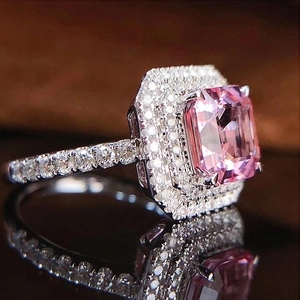Detail view of pink rectangular zirconia ring with double halo and paved side stones