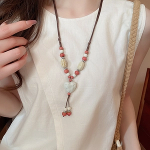 Détail du pendentif en céramique en forme de cœur avec perles émaillées et cordon tressé