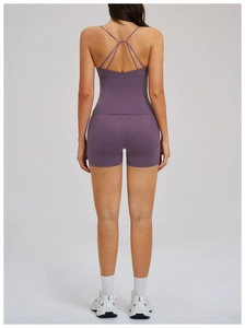 Rear view of purple yoga set featuring cross-back sports bra and high-waisted gym shorts