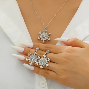 Detailed view of silver snowflake earrings and necklace with rhinestones and pearls on a model