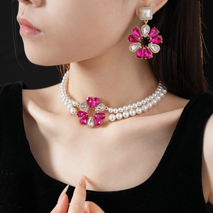 Dettaglio dell'elegante set con collana di perle a due fili e orecchini a fiore