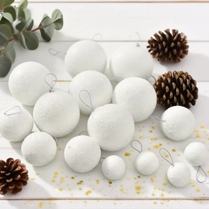 White frosted Christmas foam balls in various sizes with silver hanging strings on wood
