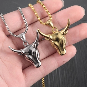 Gold and silver bull head pendant necklaces with sturdy box chains held in hand