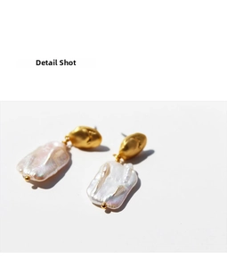 Macro detail of French vintage square baroque pearl earrings with matte gold plating
