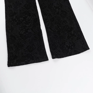 Detail of floral butterfly velvet fabric texture and hem stitching on black flared pants