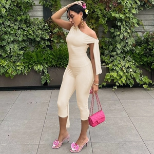 Detail of off-white one-shoulder romper with slim fit design and elegant chain handbag