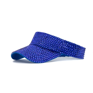 Detail of royal blue sun visor hat fully covered with shiny circular rhinestones