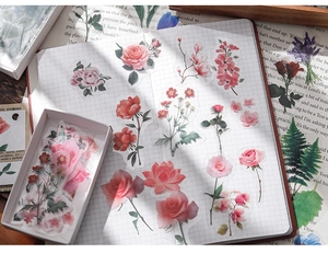 Detailed view of vintage transparent botanical flower stickers on a grid journal page