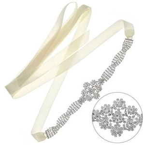 Gros plan détaillé sur une ceinture de mariée en satin crème avec motifs de feuilles strassées