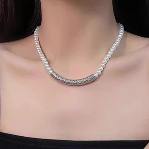 Detail of beaded pearl necklace with silver crystal bar on neck for styling