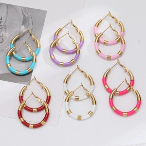 Detail showing six pairs of gold-plated hoop earrings with vibrant colorful enamel segments