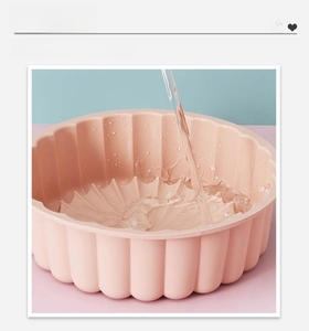 Water rinsing a pink silicone sunflower cake mold showing the easy clean seamless design