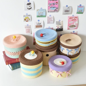 Detailed texture of hand-woven cotton rope storage baskets with colorful lids and bows