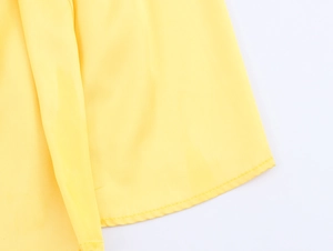 Detailed macro view of yellow satin fabric with high-quality stitched hem finish