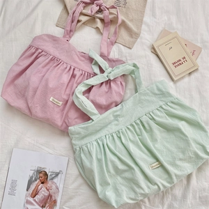 Detail of pink and mint green pleated canvas tote bags with stylish bow tie straps