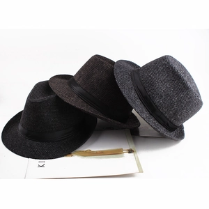Gros plan de chapeaux jazz à carreaux empilés en noir, marron et gris avec ruban