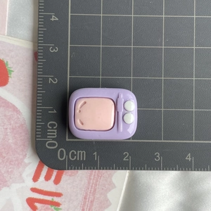 Detailed view of a mini purple resin retro TV charm on a scale showing 1.8cm size