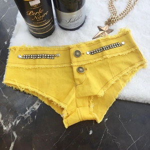 Flachliegende gelbe Denim-Hotpants mit Strassfransen und Metallknopf-Verzierung