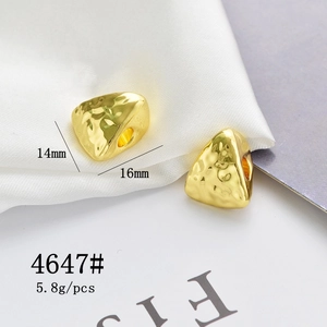Macro shot of 14x16mm golden triangular hammer textured beads for jewelry making