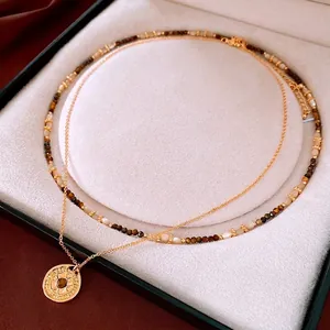 Gold plated compass necklace with tiger eye beads in a beige velvet jewelry box