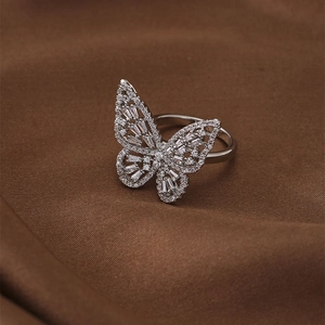 Elegant silver butterfly open ring with sparkling zircon stones on dark silk fabric