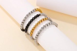 Detail of square box chain bracelets in silver, black, gold, and two-tone finishes
