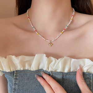 Close-up of a colorful beaded mushroom necklace worn on a neck for beach vacation style