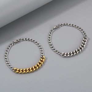 Close-up of dual-tone gold and silver Cuban link bracelets with lobster clasps