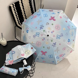 Detail of light blue sun umbrella with butterfly prints and decorative bowtie accessories
