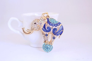Detail shot of golden rhinestone elephant pendant with blue enamel and crystal ball
