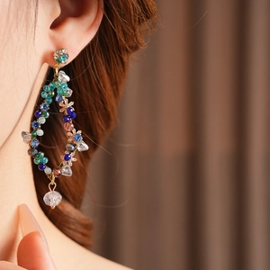 Close-up of vintage tassel earrings with colorful crystal beads in a diamond-shaped design